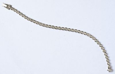 un gros plan d'une chaîne en argent ornée de perles sur un fond blanc
