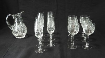 six verres à vin en cristal et un pichet sur fond noir