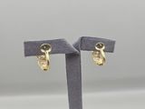 a pair of gold earrings on a stand