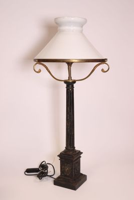 une lampe surmontée d'un abat-jour blanc