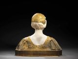 a white marble bust of a woman with a gold headpiece