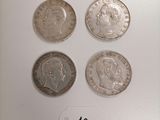 four different types of coins are shown on a white surface
