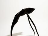 a black sculpture of a bird on a white surface