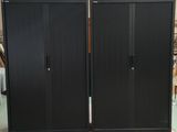 une grande armoire noire au milieu d'une pièce