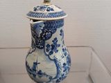 a blue and white vase with a lid on display