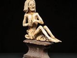 an image of a statue of a woman sitting on top of a table