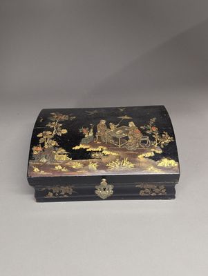 une boîte noire et dorée posée sur une table blanche
