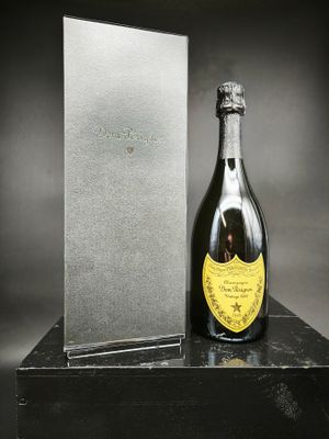 une bouteille de champagne posée sur une table à côté d'un coffret