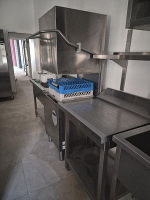 a large stainless steel kitchen with a sink and a refrigerator