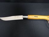 a knife with a yellow handle on a black surface