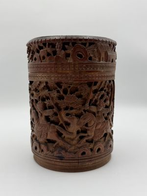 une vieille boîte en bois sculptée posée sur une surface blanche