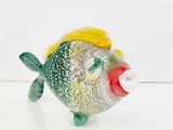 a small glass fish with a yellow hat on it ' s head