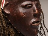 un masque africain orné de dreadlocks et d'un foulard
