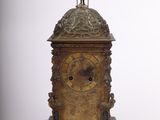 une horloge en bronze surmontée d'une statue