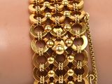 gold plated bracelet with a chain and beads on a woman ' s arm