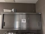 un lavabo en acier inoxydable dans une salle de bains, surmonté d'un grand miroir