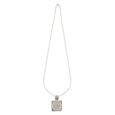 un collier en argent avec un pendentif carré au bout d'une chaîne
