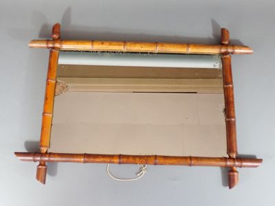 un miroir accroché au mur, avec un cadre en bambou