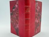 un livre rouge ouvert sur une surface blanche
