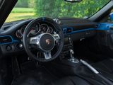 the interior of a blue sports car with a steering wheel and dashboard