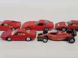 six red toy cars that are lined up on a white surface