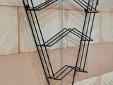 a black wire rack with three shelves attached to it
