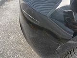 a black car that has a flat tire on the street