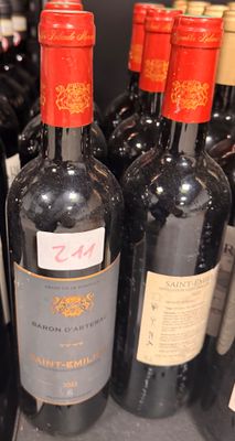 plusieurs bouteilles de vin sont alignées sur une étagère dans un magasin