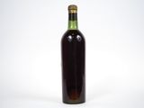 une image représentant une bouteille de vin posée sur une surface blanche
