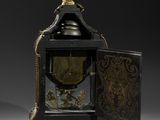 a small clock with a bell on top of it