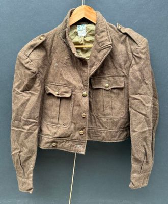 an old jacket hanging on a hanger on a wall