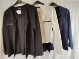 three jackets hanging on a clothes hanger in a room