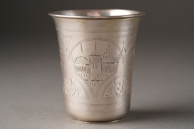 a silver cup with a design on it on a table