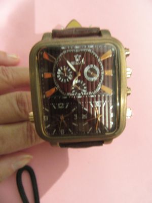 une personne tenant une montre à la main sur un fond rose
