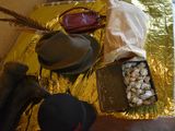 a hat, a bag, a pair of shoes, and other items on a table