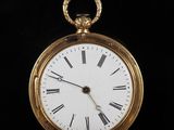 une montre de poche en or avec des chiffres romains sur le cadran