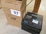 une pile de livres posée par terre à côté d'une boîte de DVD