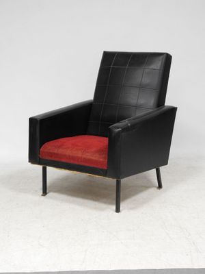 a black and red chair with a red cushion on a white floor