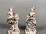 two figurines of a man and a woman with a child