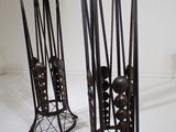 two metal vases that are sitting on a white surface