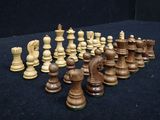 many pieces of chess on a black surface