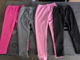 trois paires de pantalons roses et noirs posées sur une table