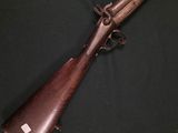 un vieux pistolet avec un canon en bois et une poignée en métal