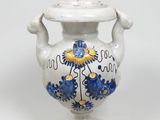 un vase blanc orné d'un motif bleu et jaune