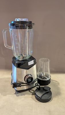 un mixeur posé sur un plan de travail, avec un verre à côté
