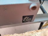 a close up of a piece of wood with a machine in the background