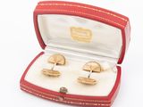 two pairs of cufflinks in a red box on a white surface