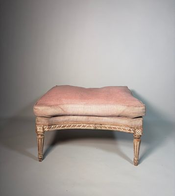 an old bench with a pink upholstered cushion on it
