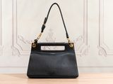 a black handbag sitting on top of a wooden table