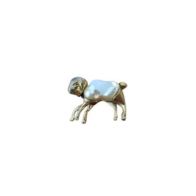 une petite statue représentant un mouton avec une couverture bleue sur le dos
